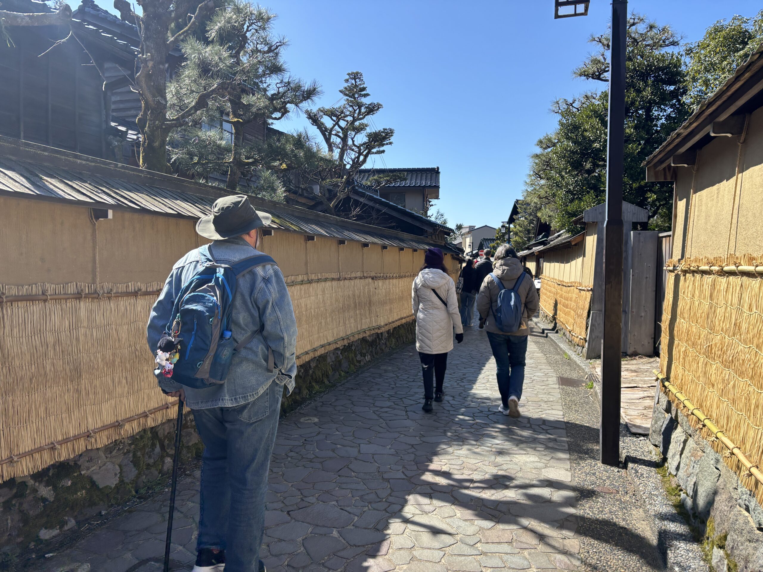 Visitors walking between the earthen walls of Nagamachi Samurai District in Kanazawa