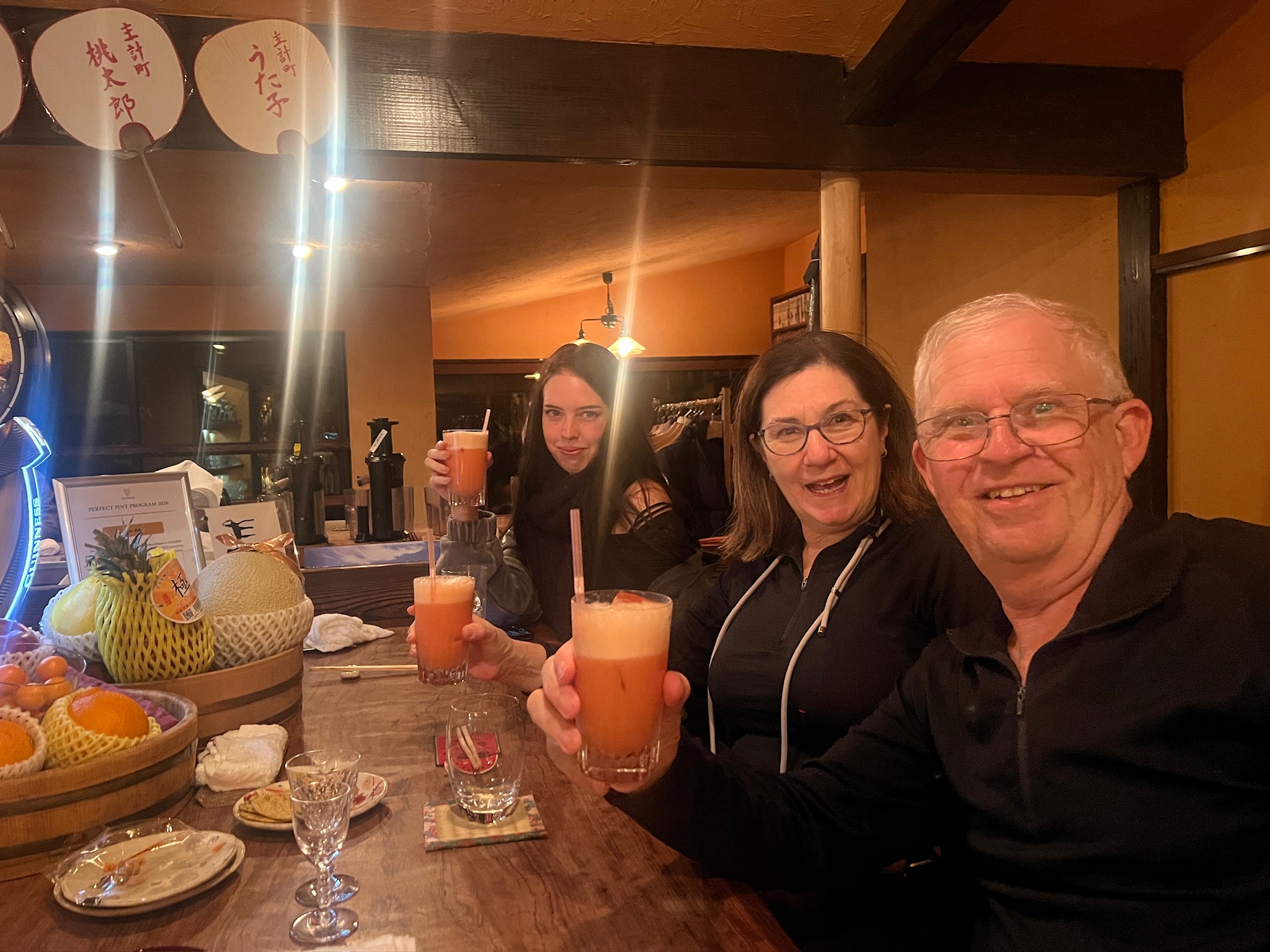 Guests sharing drinks at a counter during a Kanazawa izakaya tour