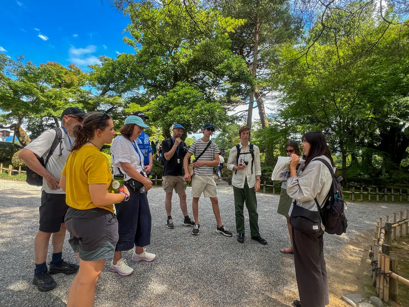 Local Amazing Tour Japan guide explaining Kanazawa to international guests in a garden
