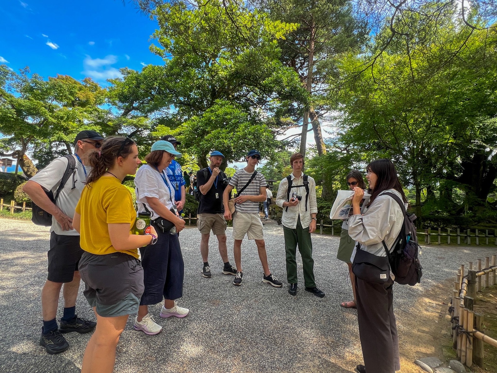 Amazing Tour Japanのガイドが金沢の庭園で外国人ゲストを案内する様子