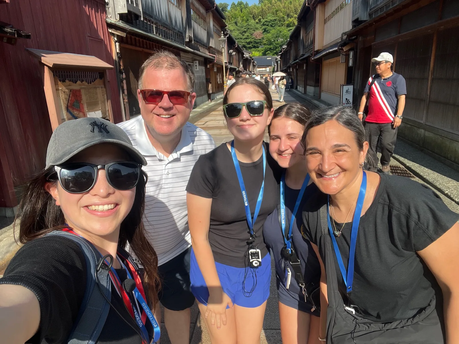 Guía y viajeros sonrientes después de un tour por Higashi Chaya en Kanazawa